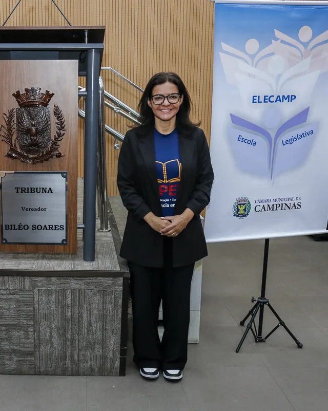 Nelly Castanheira ao lado do banner da Escola do Legislativo de Campinas (Elecamp), na Câmara Municipal de Campinas.